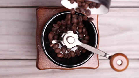 Roasted coffee beans falling into vintage manual coffee grinder. Video stock 153050502