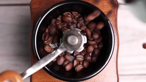 Roasted coffee beans falling into vintage manual coffee grinder. Video stock 153052675