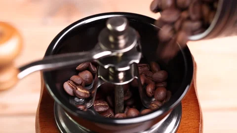 Roasted coffee beans falling into vintage manual coffee grinder. Video stock 153052941