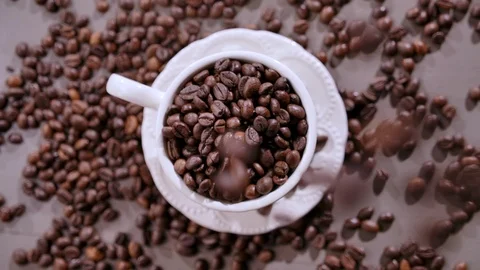 Roasted coffee beans falls down in cup. Top view. Coffee grains falling. Stock-Footage 120557265