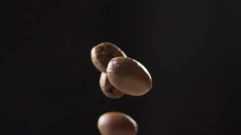 Roasted coffee beans flying through the air in a curved motion 動画素材 316070644