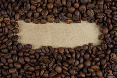 Roasted coffee beans framing blank kraft paper space Foto stock