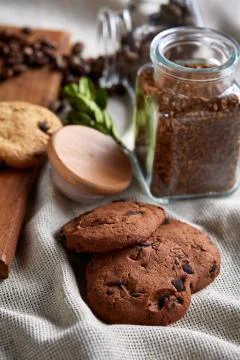 Roasted coffee beans get out of overturned glass jar on homespun tablecloth Stock Photos