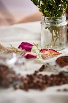 Roasted coffee beans get out of overturned glass jar on homespun tablecloth Stock Photos