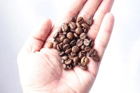 Roasted Coffee beans in hand isolated Stock Photos