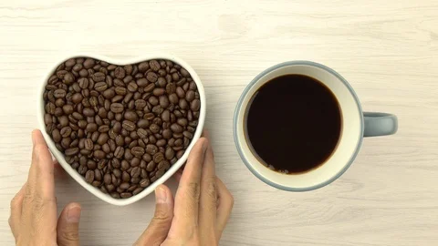 Roasted coffee beans in heart shape with coffee cup Stock-Footage 104805920