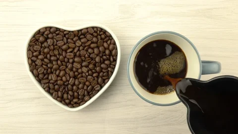 Roasted coffee beans in heart shape with coffee cup Stock Footage 104806283