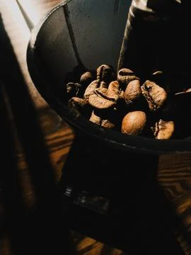 Roasted coffee beans inside coffee grinder illuminated by ray of light. Roasted Stock Photos