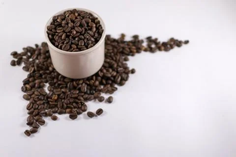 Roasted Coffee Beans Inside a Cup with Copyspace on White Cardboard Stock Photos