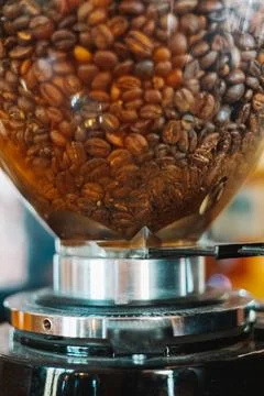 Roasted coffee beans inside a professional coffee grinder Stock Photos