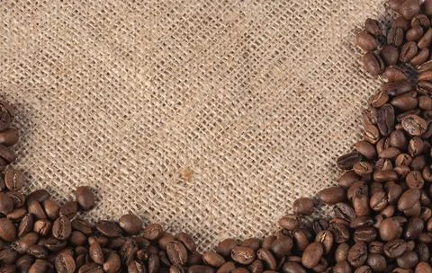 Roasted coffee beans on a jute background with space for your text Stock Photos