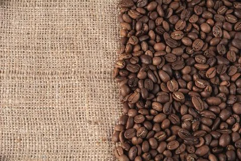 Roasted coffee beans on a jute background with space for your text Stock Photos