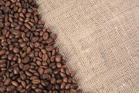Roasted coffee beans on a jute background with space for your text Stock Photos