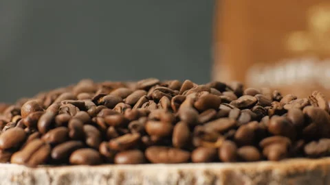 Roasted coffee beans lie in a heap. Smoke rises in front of the grains Stock Footage 263063650