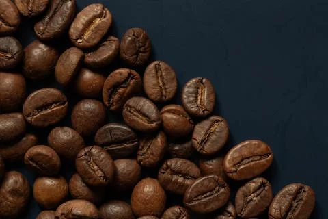 Roasted coffee beans lying on a dark blue background 스톡 사진