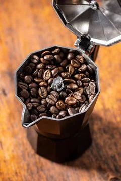 Roasted coffee beans in mocca pot Roasted coffee beans in mocha pot on woo... Stock Photos