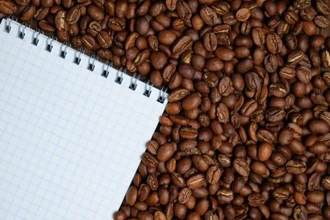 Roasted coffee beans with paper notepad. Copy space. Top view. 스톡 사진