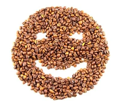 Roasted coffee beans placed in the shape of a smiling face Foto stock
