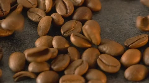 Roasted coffee beans poured on dark textured table, macro close up background Stock Footage 273075240