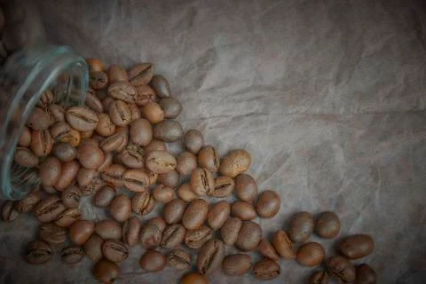 Roasted coffee beans poured from a glass jar. angular placement of the coffee Stock Photos