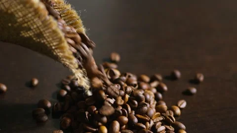 Roasted Coffee Beans Pouring Out of Burlap Sack onto Table. indoor shot, stable Stock Footage 348692422