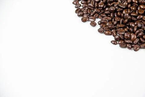 The roasted coffee beans put at the corner top right of white background,blur Stock Photos