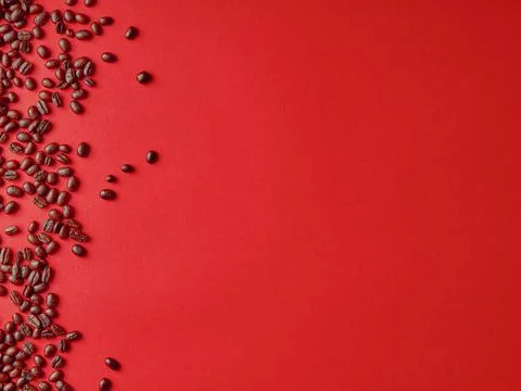 Roasted coffee beans on red background, with copy space. Stock Photos