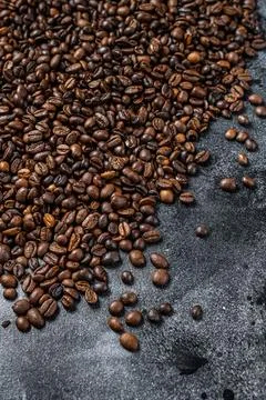 Roasted coffee beans on rustic table. Black background. Top view Stock Photos