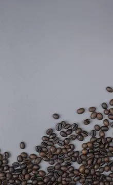 Roasted Coffee Beans Scattered on Gray Background with Empty Space Stock Photos