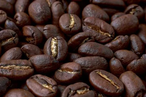 Roasted coffee beans scattered in random order on a dark background Foto stock