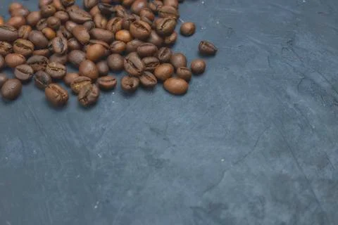 Roasted coffee beans scattering in the corner of the background. beans on a d Stock Photos