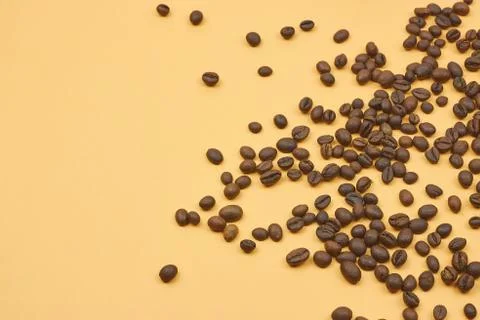 Roasted coffee beans scattering in the corner of the background. beans on a d Stock Photos