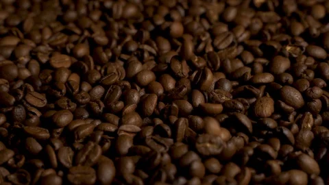 Roasted coffee beans scrolls slowly in circle and coffee beans falling down. Vídeos de archivo 128315675