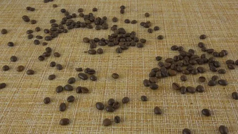 Roasted coffee beans slowly fall onto the table. Slow motion Stockbeeldmateriaal 116599170