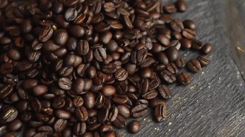 Roasted coffee beans slowly rolling down a dark wooden surface Stock Footage 329966695