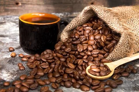 Roasted coffee beans in small sack and cup of coffee Stock-Fotos