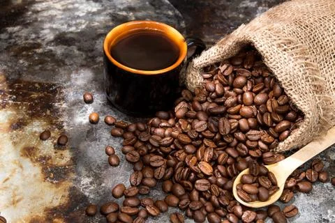 Roasted coffee beans in small sack and cup of coffee Stock Photos