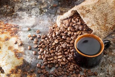 Roasted coffee beans in small sack and cup of coffee Stock Photos