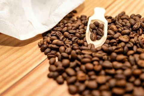 Roasted Coffee Beans Spill on Wooden Table Stock Photos