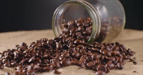 Roasted Coffee Beans Spilled From Jar On Hessian Sack 4K Stock Footage 86084840