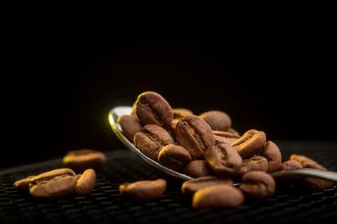 Roasted Coffee Beans on Spoon and Surface Stock Photos
