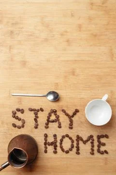 Roasted coffee beans, a spoon, a copper cezva and a white porcelain cup 스톡 사진