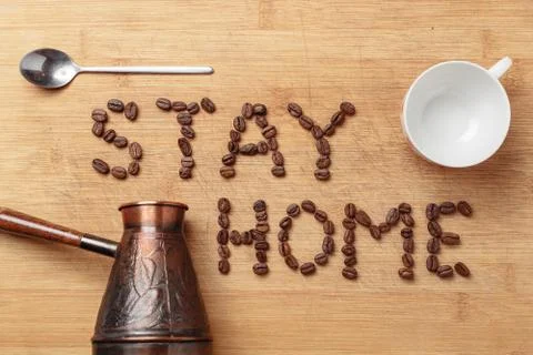 Roasted coffee beans, a spoon, a copper cezva and a white porcelain cup Foto stock