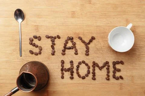 Roasted coffee beans, a spoon, a copper cezva and a white porcelain cup Stock Photos