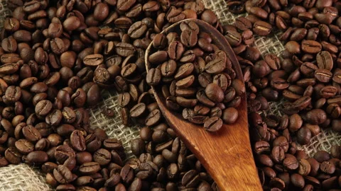 Roasted coffee beans in spoon top view. Wooden spoon with coffee beans in burlap Stock Footage 308324552