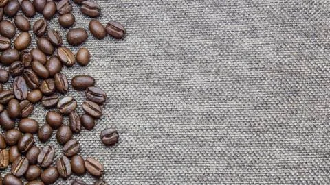 Roasted coffee beans spread around burlap texture background. With available Stock Photos