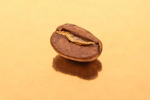 Roasted coffee beans in a structured pattern on a glossy golden background,.. Stock Photos