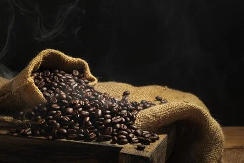 Roasted coffee beans on the table with a black background and dark colors Stock Photos