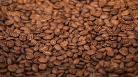 Roasted coffee beans on a table. Smooth rotating motion. Close up Stock Footage 76346624