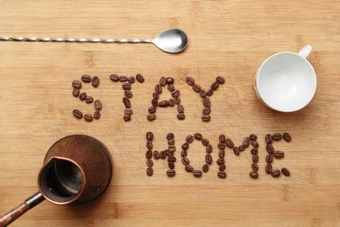 Roasted coffee beans, a twisted spoon, a copper cezva and a white porcelain cup 스톡 사진